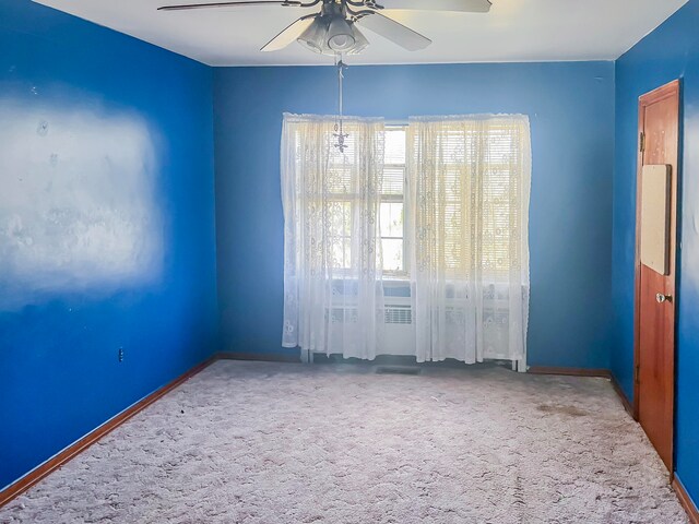 carpeted spare room with ceiling fan