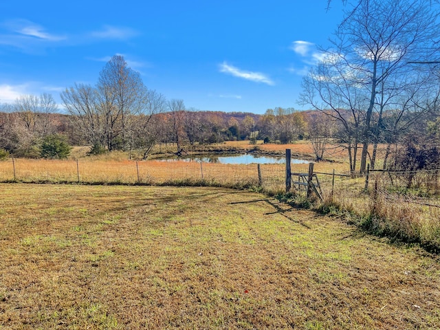 view of yard with a water view and a rural view