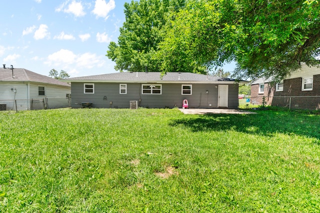 back of property with a lawn and a patio area