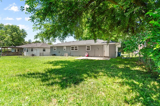 back of property with a yard and a patio