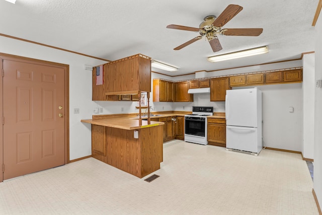 kitchen with a textured ceiling, ceiling fan, white appliances, and kitchen peninsula