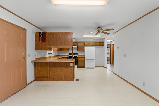 kitchen featuring kitchen peninsula, ceiling fan, white appliances, and ornamental molding