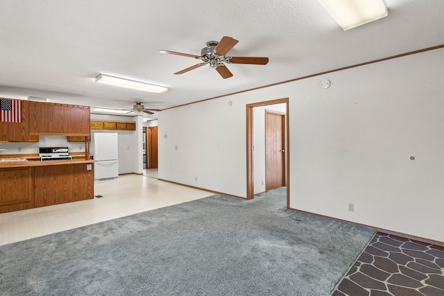 kitchen featuring kitchen peninsula, stove, a textured ceiling, sink, and white refrigerator