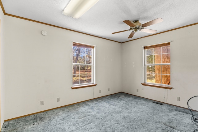 carpeted spare room featuring ceiling fan, a healthy amount of sunlight, and a textured ceiling