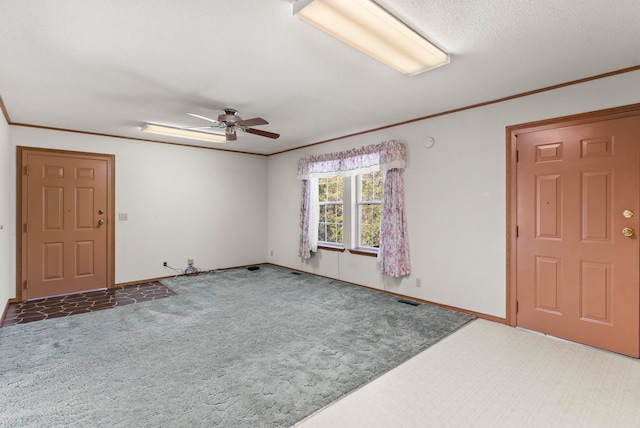 carpeted entrance foyer featuring a textured ceiling, ceiling fan, and crown molding