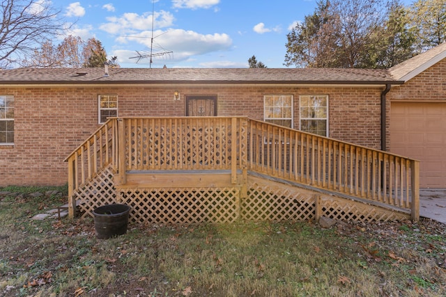 rear view of property with a garage and a wooden deck