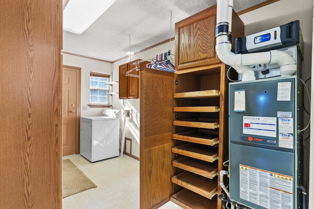 washroom featuring cabinets, washer and dryer, ornamental molding, a textured ceiling, and heating unit