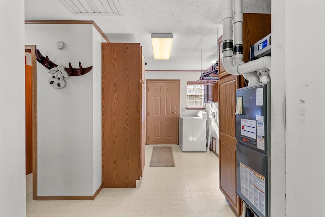 interior space featuring a textured ceiling, washer and clothes dryer, and crown molding