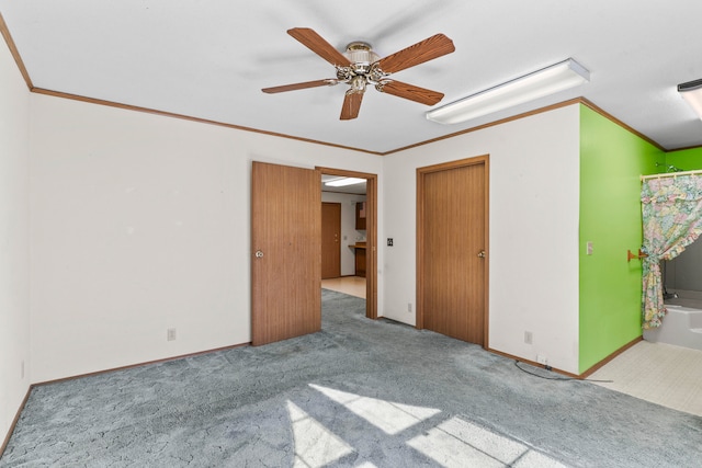 unfurnished bedroom with ceiling fan, light colored carpet, ornamental molding, and ensuite bathroom