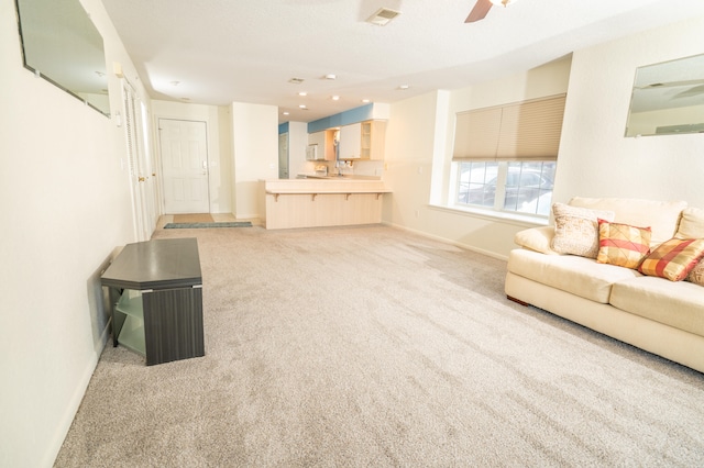 unfurnished living room with ceiling fan and light carpet