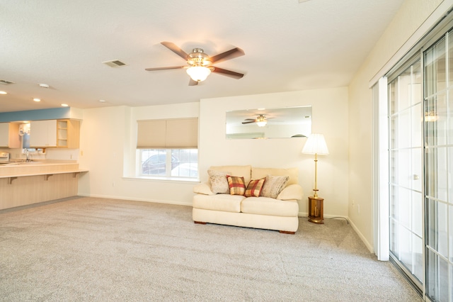 living room with ceiling fan and light colored carpet