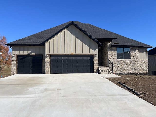 view of front facade with stone siding, driveway, a garage, and board and batten siding
