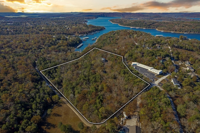 aerial view at dusk featuring a water view