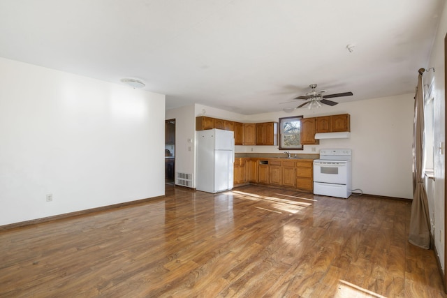 kitchen featuring ceiling fan, sink, dark wood-type flooring, and white appliances