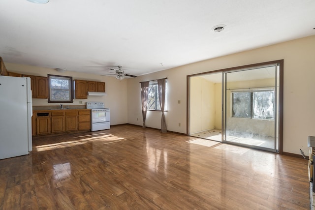 unfurnished living room featuring ceiling fan, sink, and dark wood-type flooring