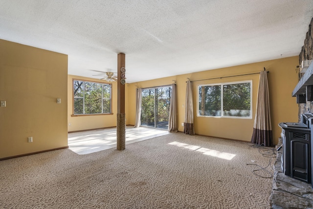 unfurnished living room with ceiling fan, light colored carpet, and a textured ceiling