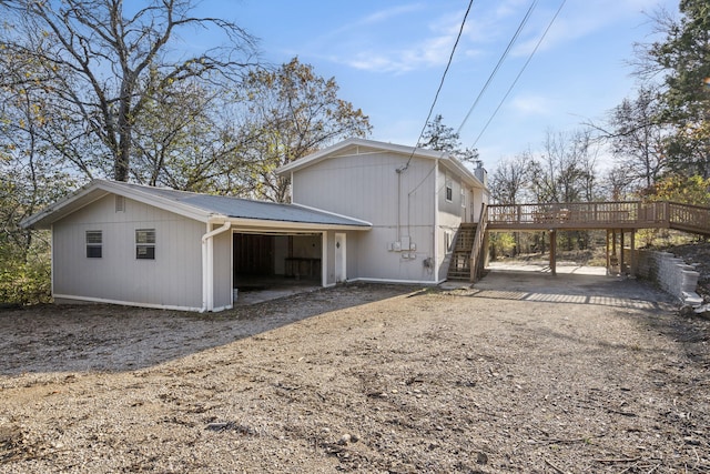 back of house featuring a garage and a wooden deck