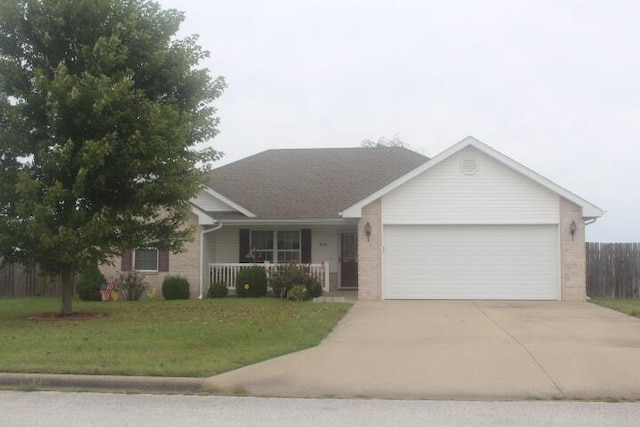 ranch-style house with covered porch, a garage, and a front lawn