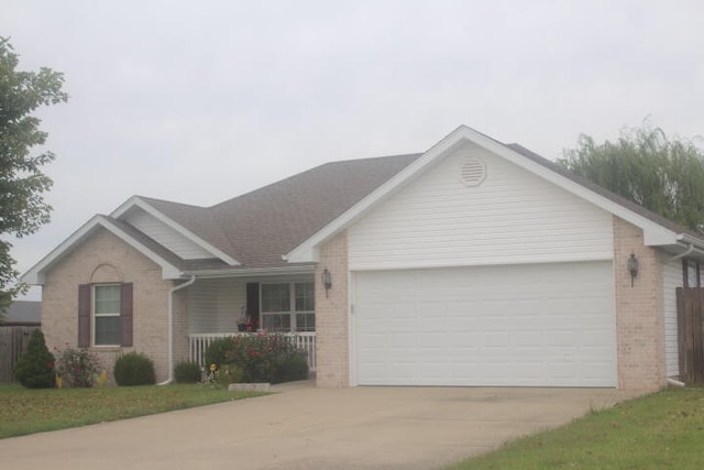 ranch-style house with covered porch, a garage, and a front yard