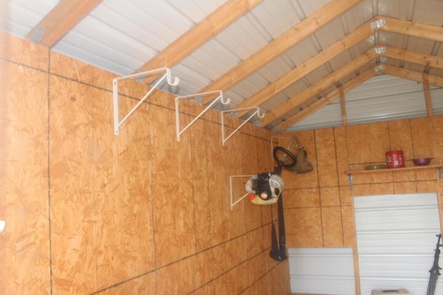 interior space with vaulted ceiling with beams and wooden walls