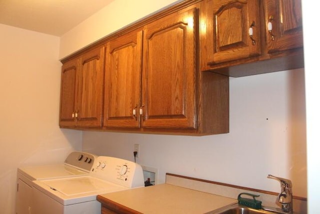 laundry room with cabinets, washer and dryer, and sink