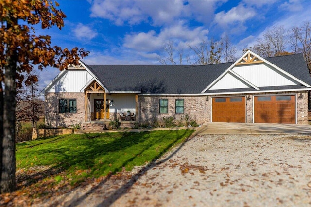 craftsman house featuring covered porch, a garage, and a front yard