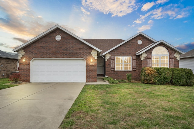 view of front of home featuring a garage and a yard