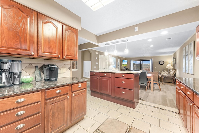 kitchen featuring decorative backsplash, pendant lighting, light hardwood / wood-style flooring, and dark stone countertops