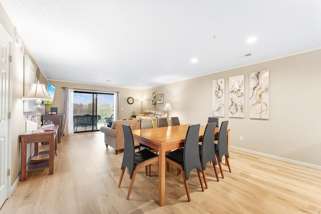 dining space featuring light hardwood / wood-style floors and ornamental molding