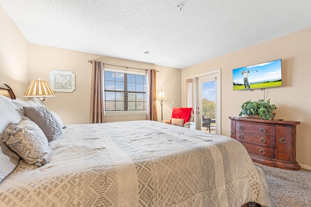 bedroom featuring access to exterior, carpet floors, and a textured ceiling