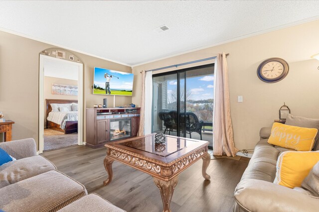 living room with a textured ceiling, dark hardwood / wood-style floors, and crown molding