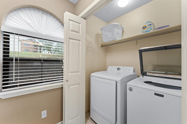 clothes washing area featuring independent washer and dryer and a textured ceiling