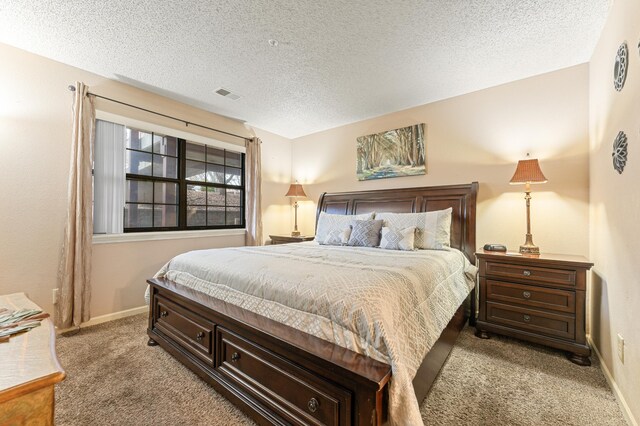 bedroom featuring light colored carpet and a textured ceiling