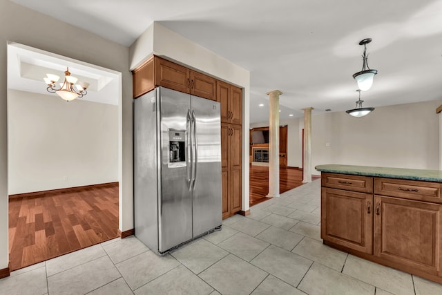 kitchen with ornate columns, stainless steel fridge with ice dispenser, light hardwood / wood-style flooring, a chandelier, and pendant lighting