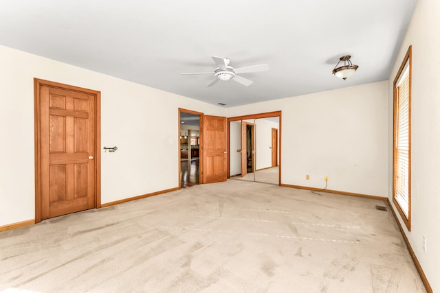 unfurnished bedroom with ceiling fan and light colored carpet