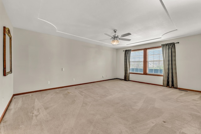 spare room with ceiling fan and light colored carpet