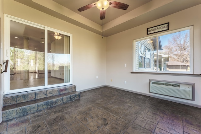 unfurnished room featuring an AC wall unit, a wealth of natural light, and ceiling fan