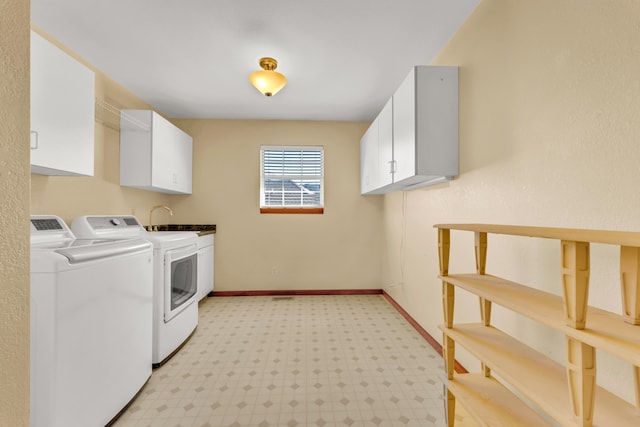 clothes washing area featuring sink, cabinets, and independent washer and dryer