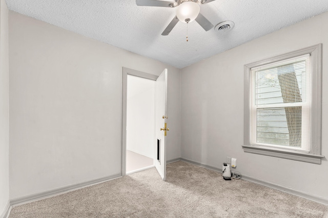 carpeted empty room featuring ceiling fan and a textured ceiling