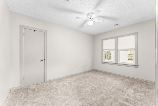 carpeted spare room with ceiling fan and a textured ceiling