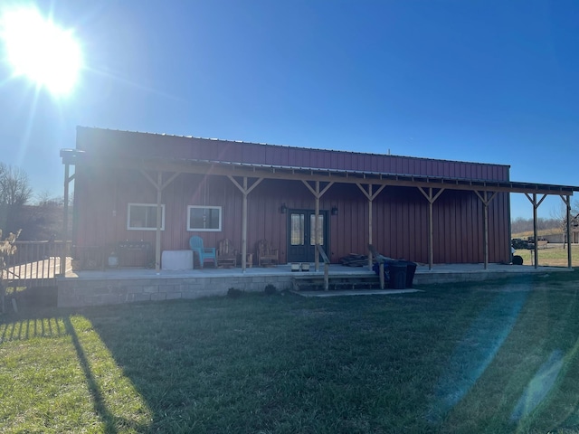 back of property with a lawn and a patio