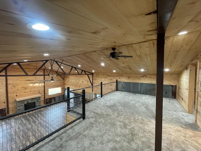 interior space with carpet flooring, ceiling fan, wooden ceiling, lofted ceiling, and wood walls