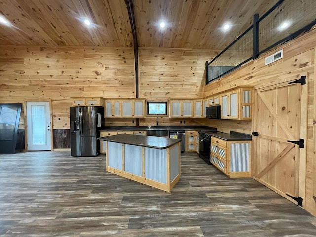 kitchen featuring a center island, high vaulted ceiling, black appliances, wooden walls, and dark hardwood / wood-style flooring