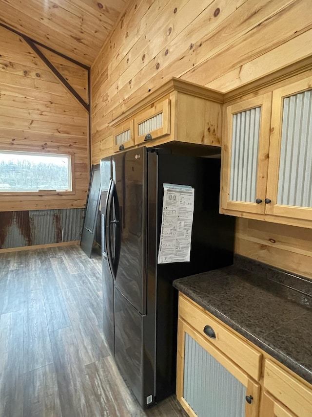 kitchen featuring light brown cabinetry, dark hardwood / wood-style flooring, wood ceiling, black fridge with ice dispenser, and wood walls