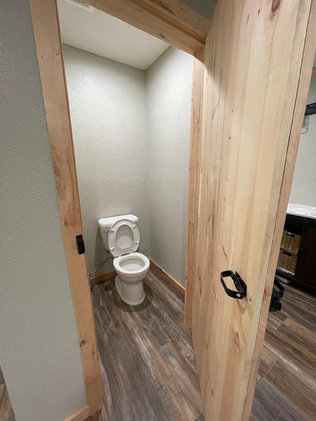 bathroom featuring wood-type flooring and toilet