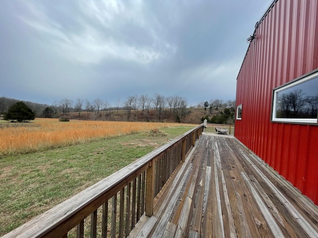 deck featuring a lawn and a rural view