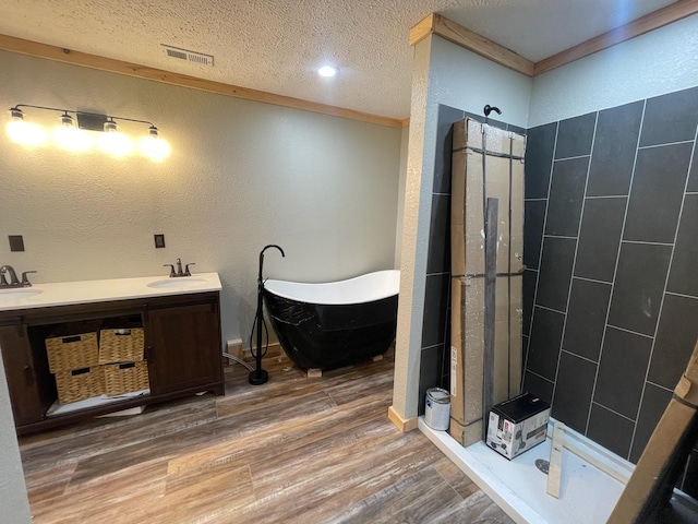 bathroom featuring crown molding, wood-type flooring, a textured ceiling, and independent shower and bath