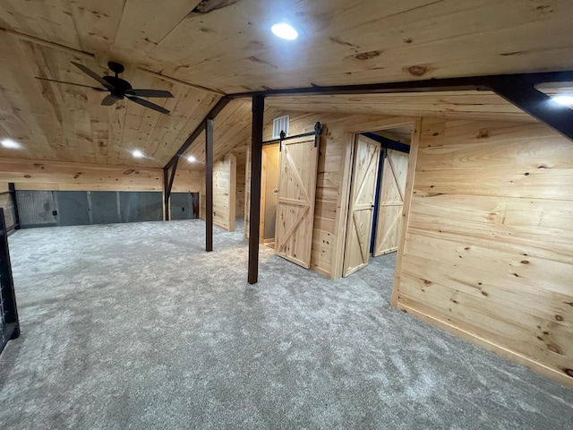 additional living space featuring carpet, wood ceiling, wooden walls, a barn door, and lofted ceiling