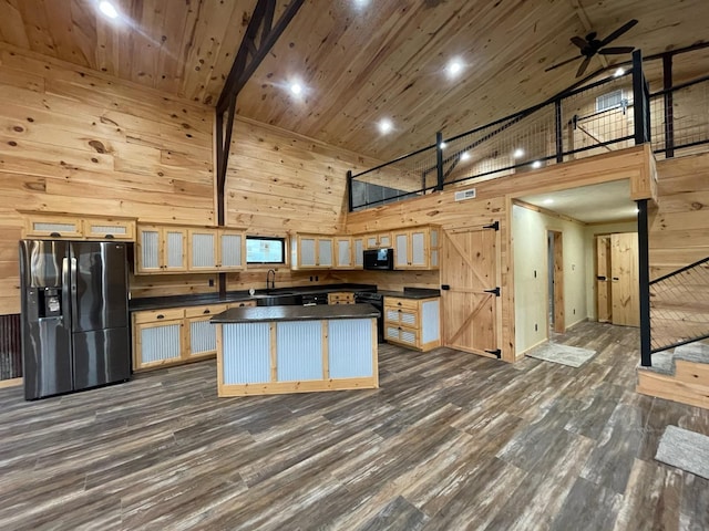 kitchen featuring high vaulted ceiling, wooden walls, dark hardwood / wood-style floors, a kitchen island, and stainless steel fridge with ice dispenser