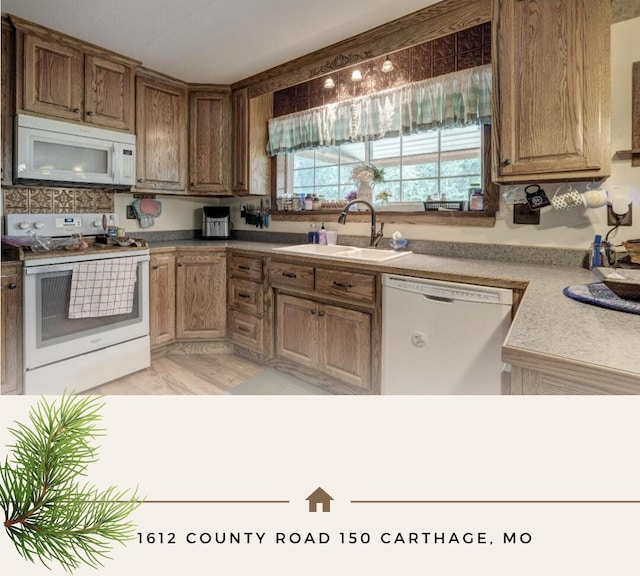 kitchen with white appliances, light hardwood / wood-style floors, and sink